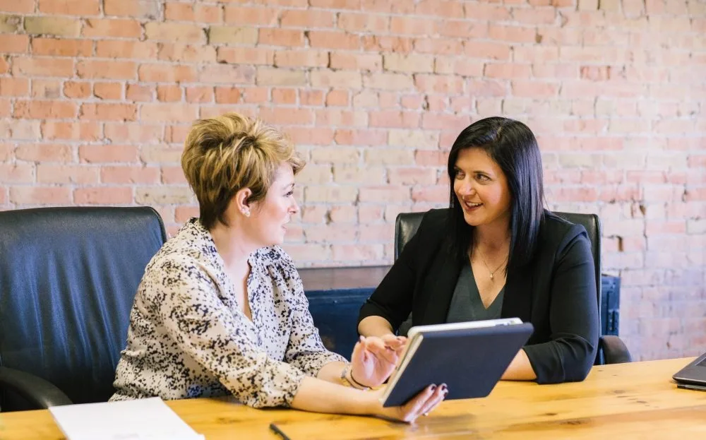 Two women working at a desk together - a blog post about successful leaders utilizing emotional intelligence.