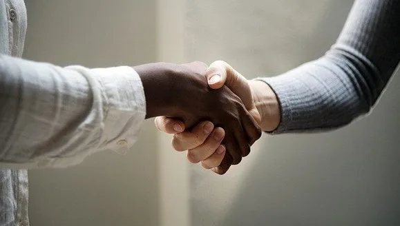 Two people shaking hands - a blog post about what questions to ask a customer to help close the sale.